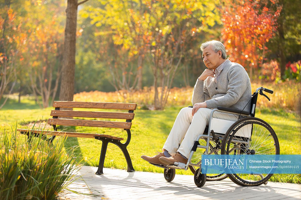 Lonely senior Chinese man sitting on wheelchair