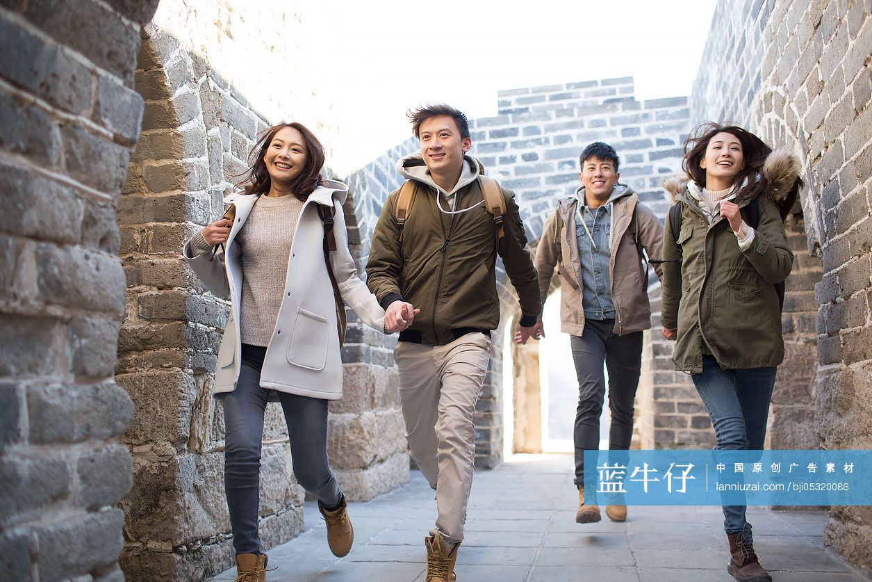 Happy young Chinese friends enjoying winter outing on the Great Wall