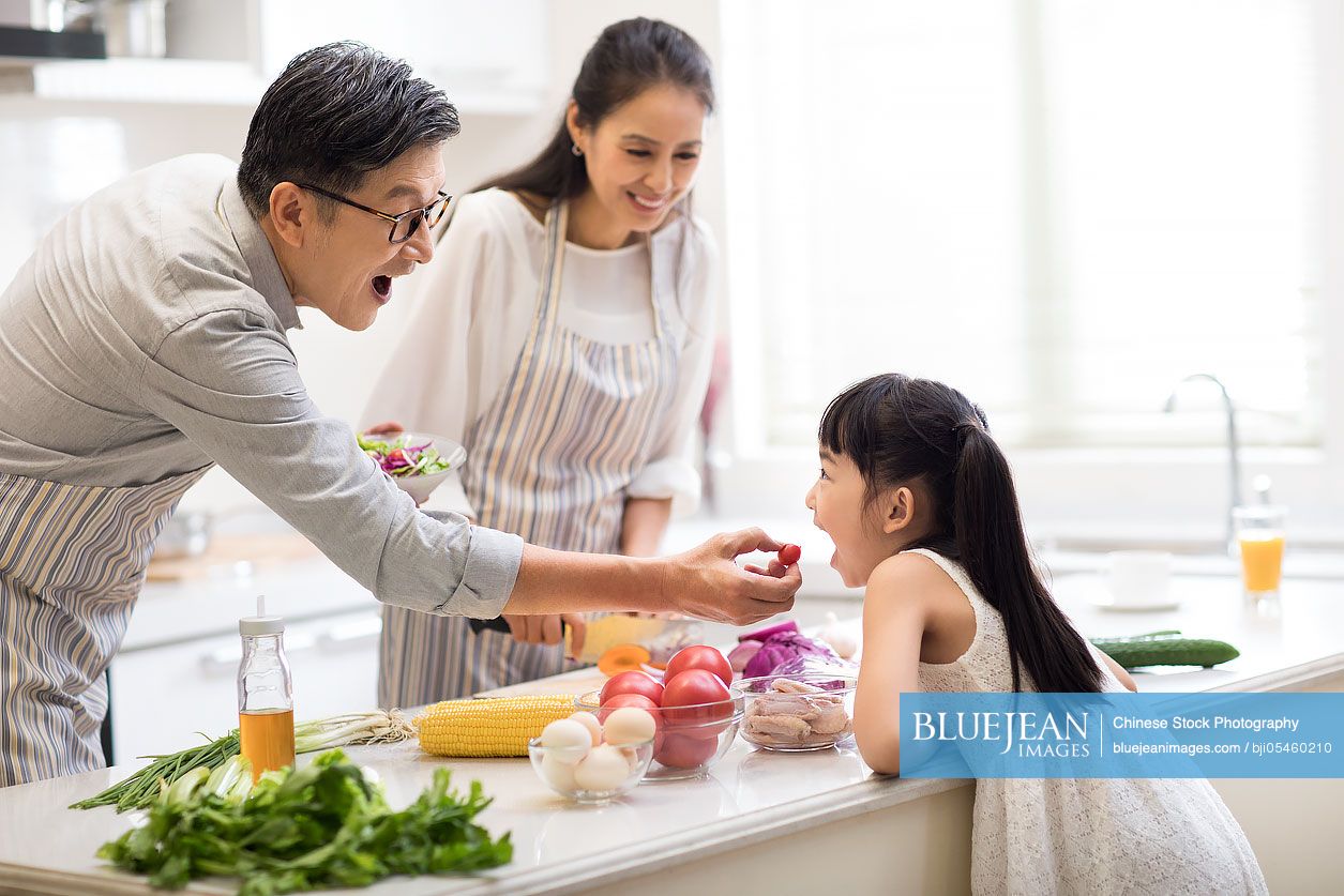 Happy Chinese family cooking in kitchen