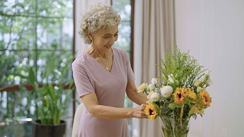 快乐的老年女子在家插花