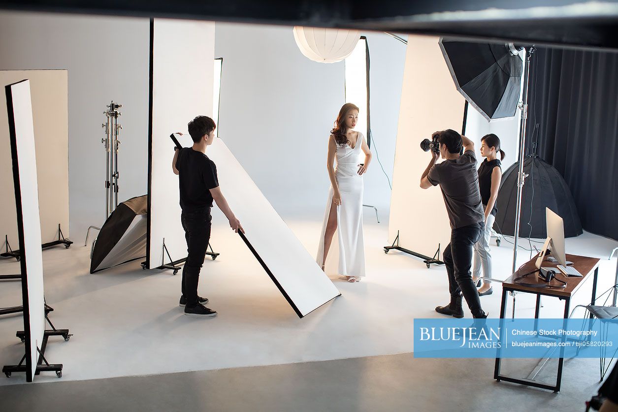 Chinese photographer taking picture of model in studio