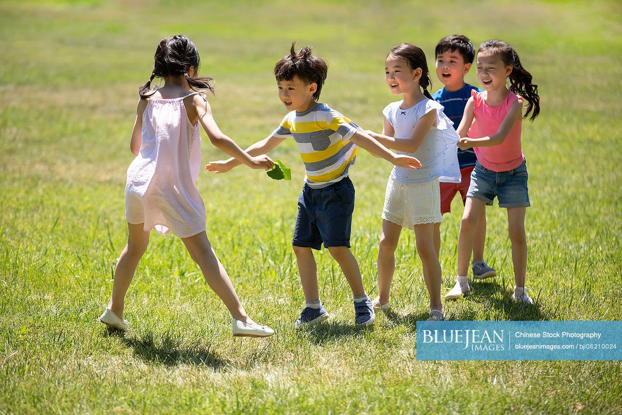 Happy Chinese children playing games on meadow