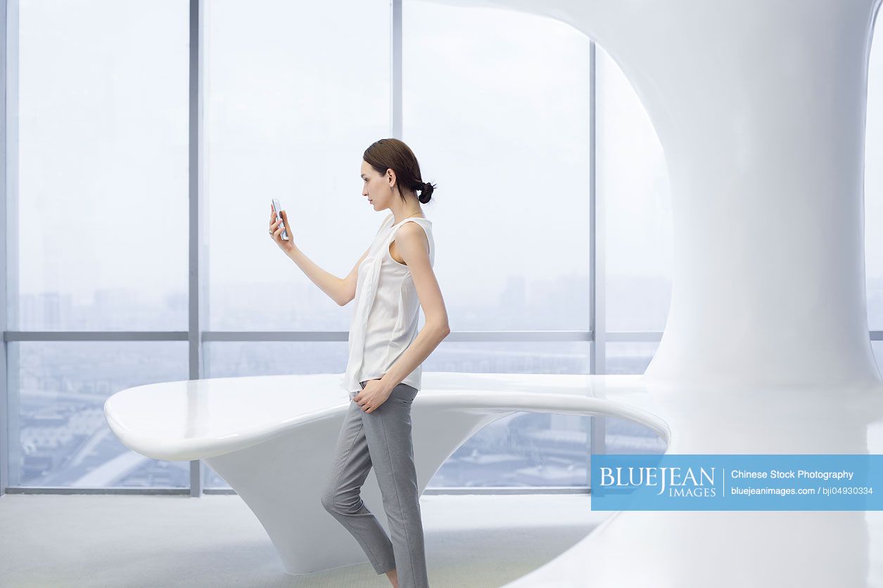 Businesswoman using smart phone in office
