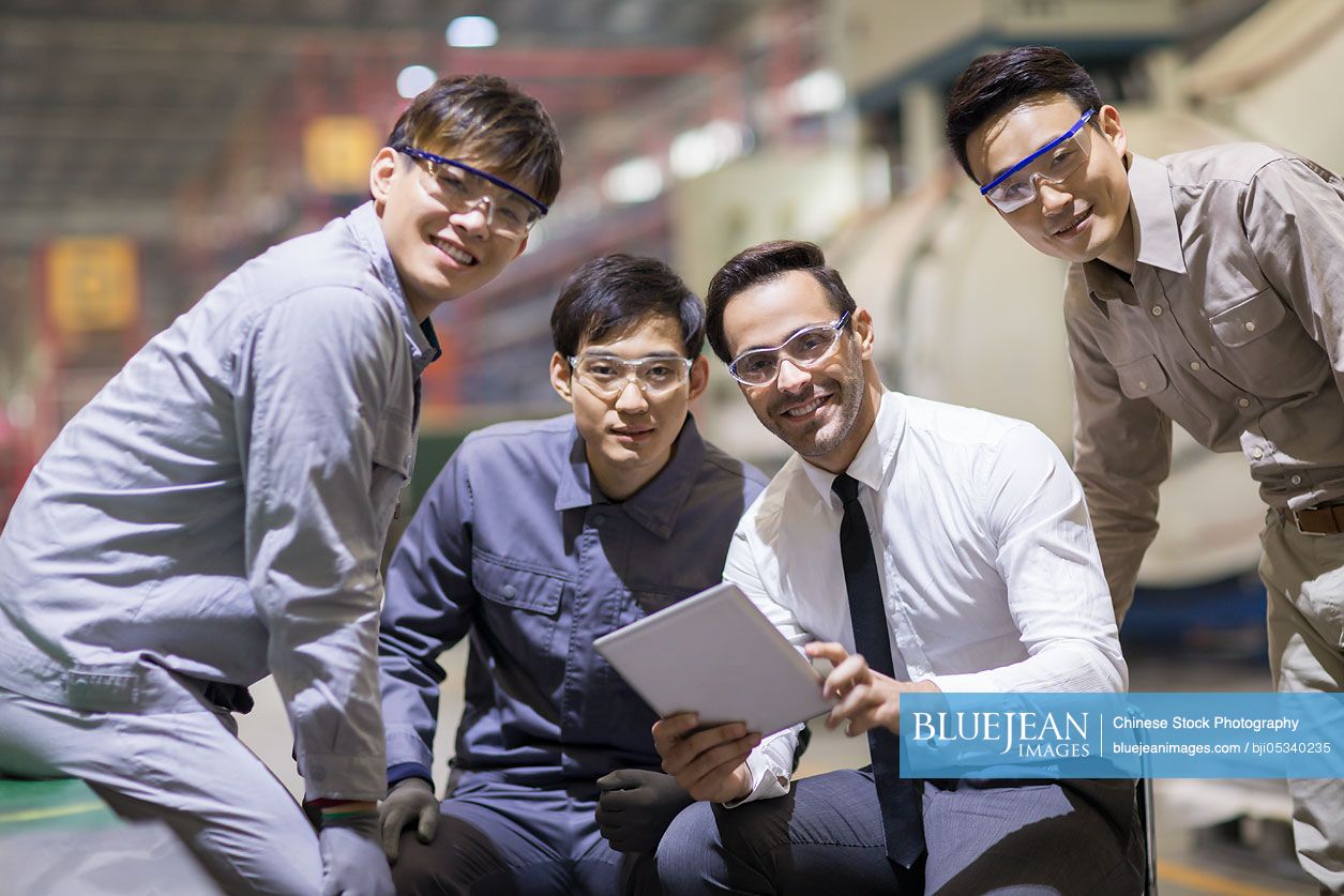 Businessman and engineers talking in the factory