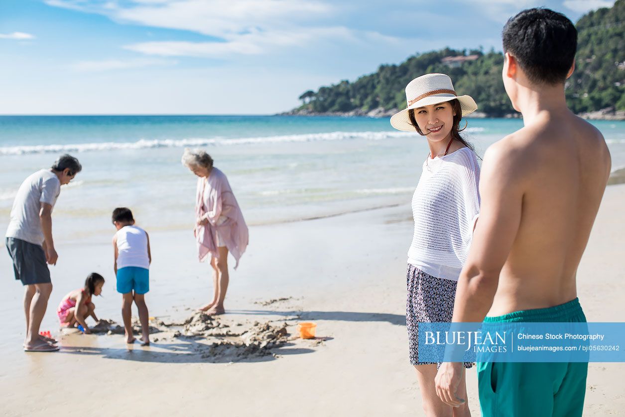 Happy Chinese family having fun on beach