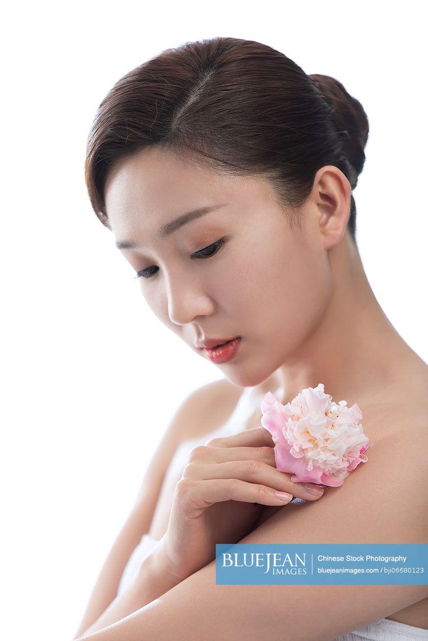 Beautiful young Chinese woman holding a flower