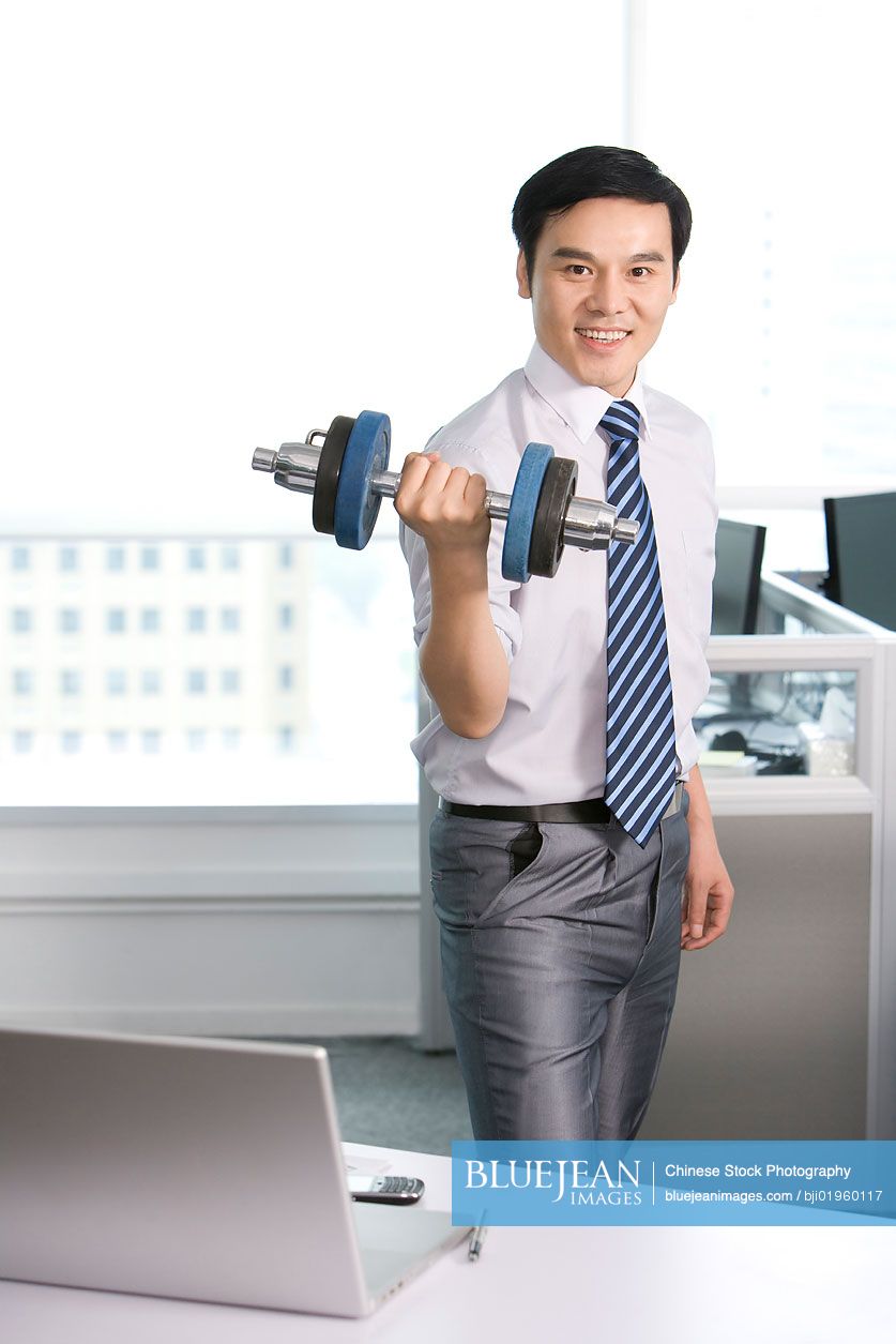 Chinese office worker working out in the office