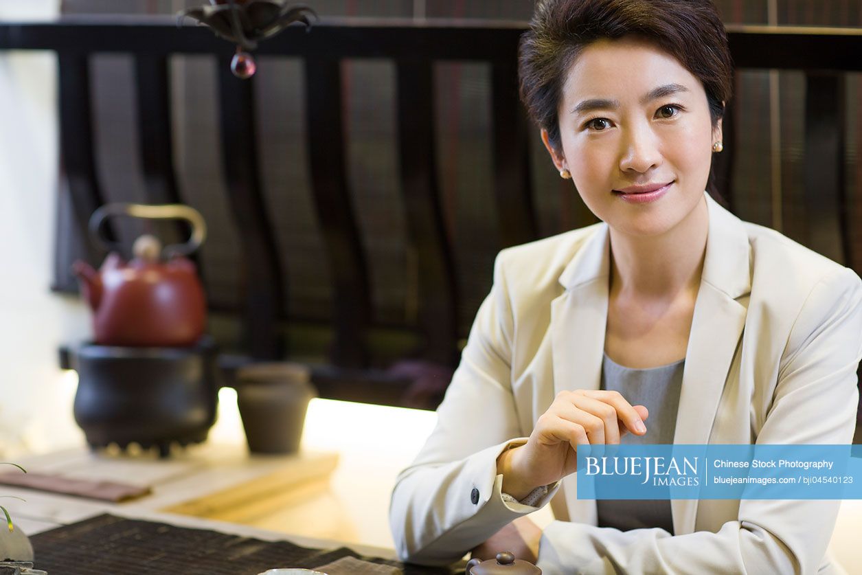 Chinese businesswoman drinking tea in tea room