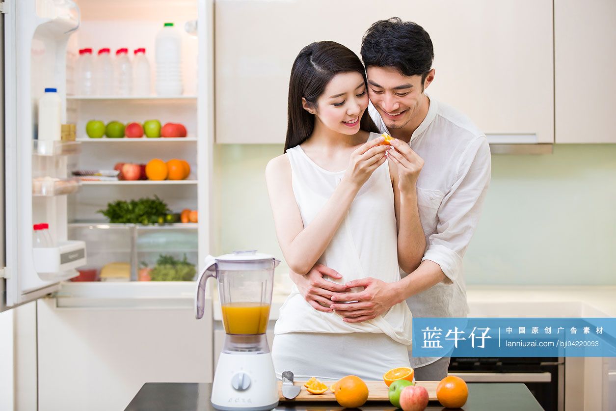 年轻夫妇在厨房切橙子