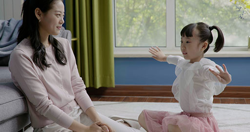 Mom and daughter dancing casually at home