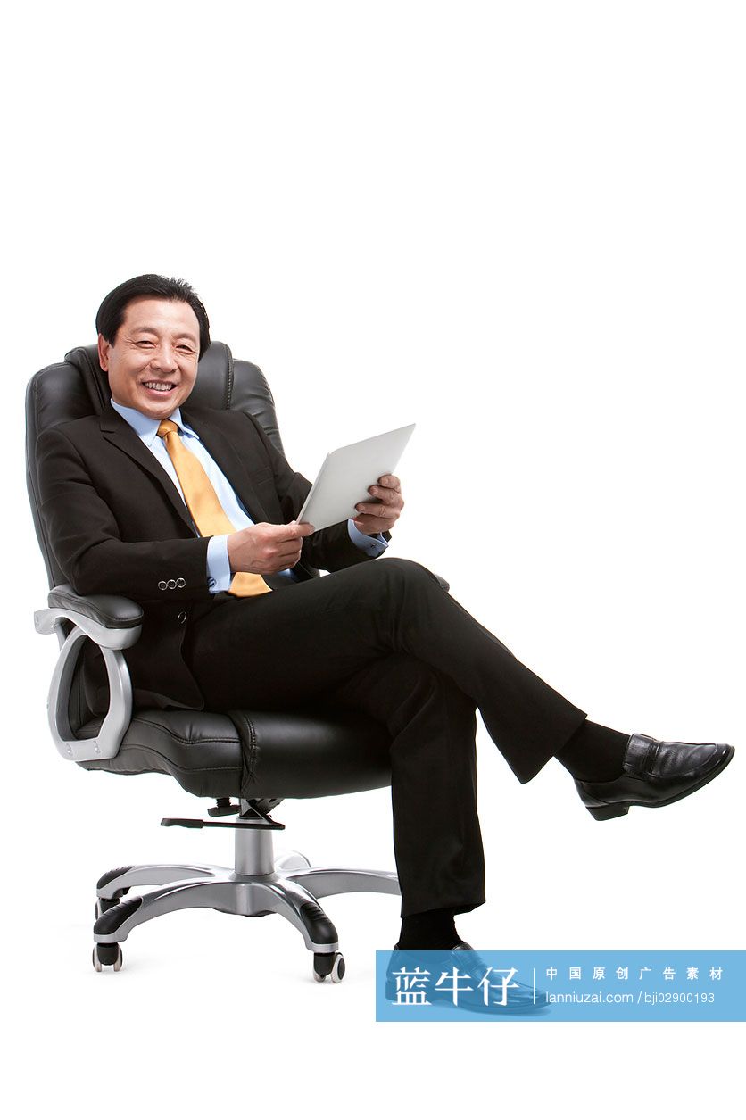 中年商务人士坐在老板椅上用平板电脑