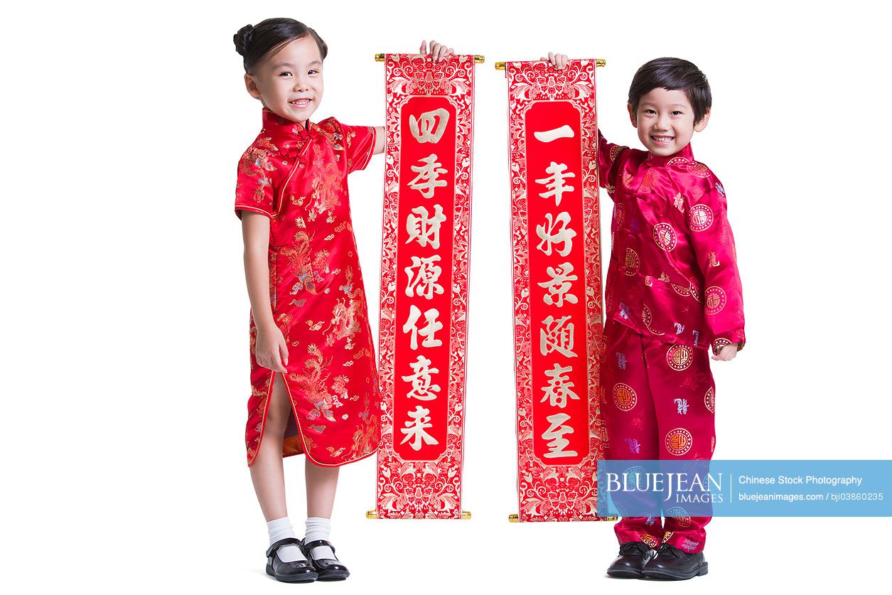 Cute Chinese children with couplets celebrating Chinese New Year