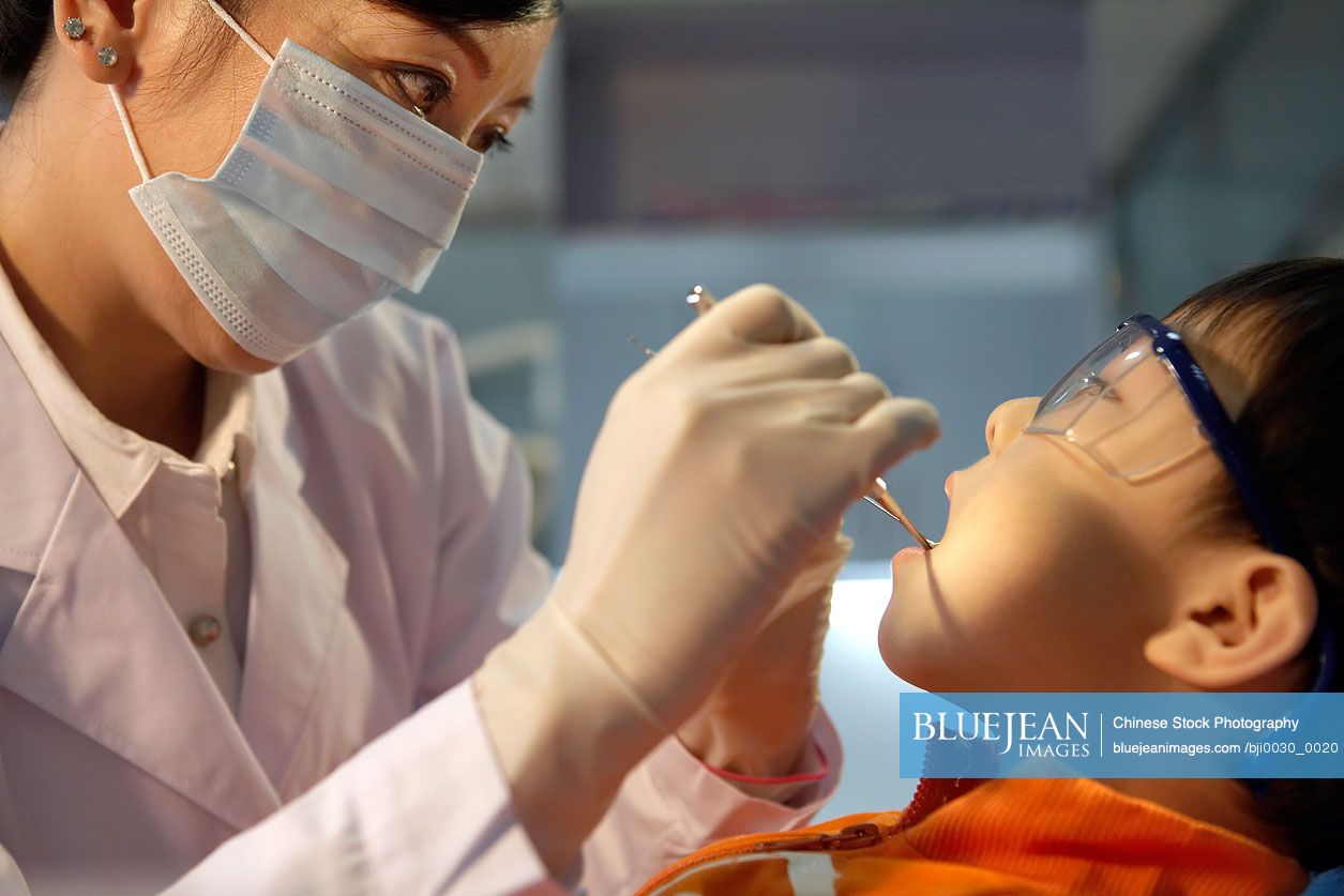 Chinese dentist examining boy's teeth