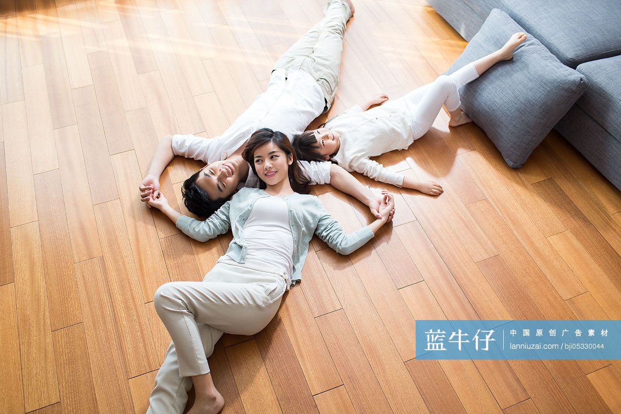 年轻家庭躺在木地板上休息