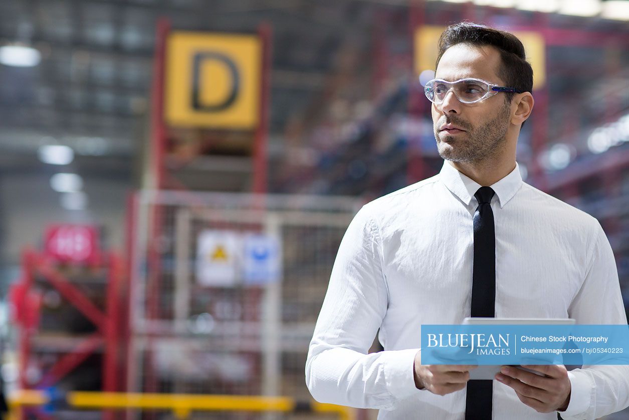 Businessman holding a digital tablet in the factory