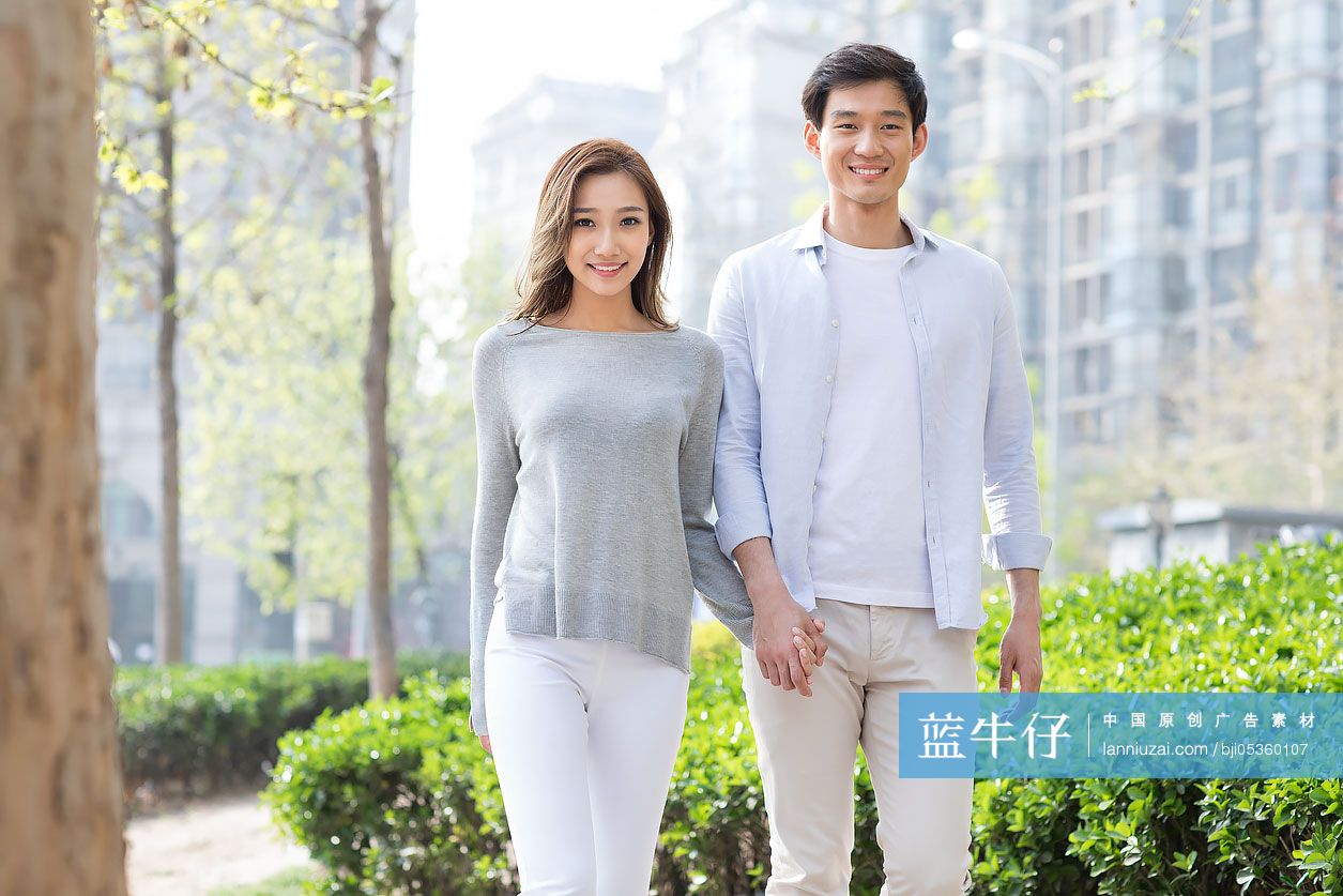 快乐的年轻情侣手牵手散步