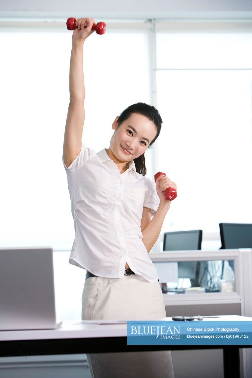 Chinese office worker working out in the office