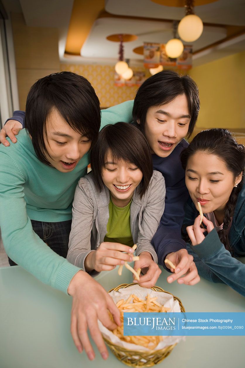 Chinese teenagers sharing French fries