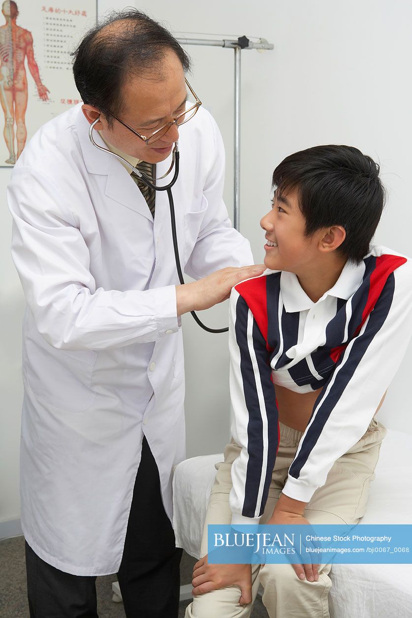 Chinese Doctor Listening To Patient's Heart With Stethoscope