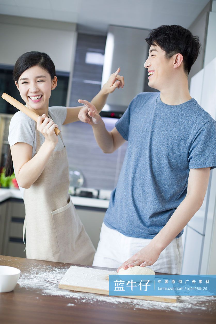 快乐的年轻夫妇在厨房做饭