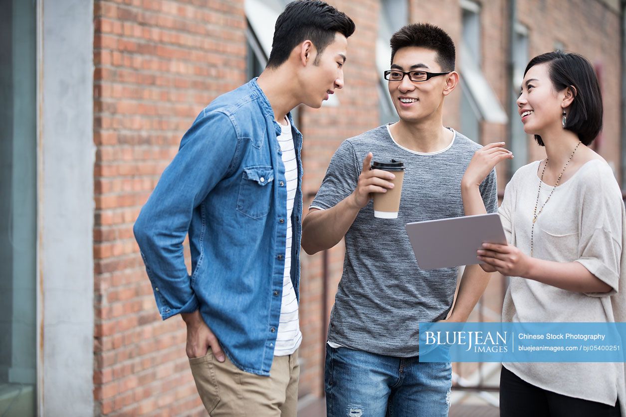 Confident Chinese designer team talking outdoors