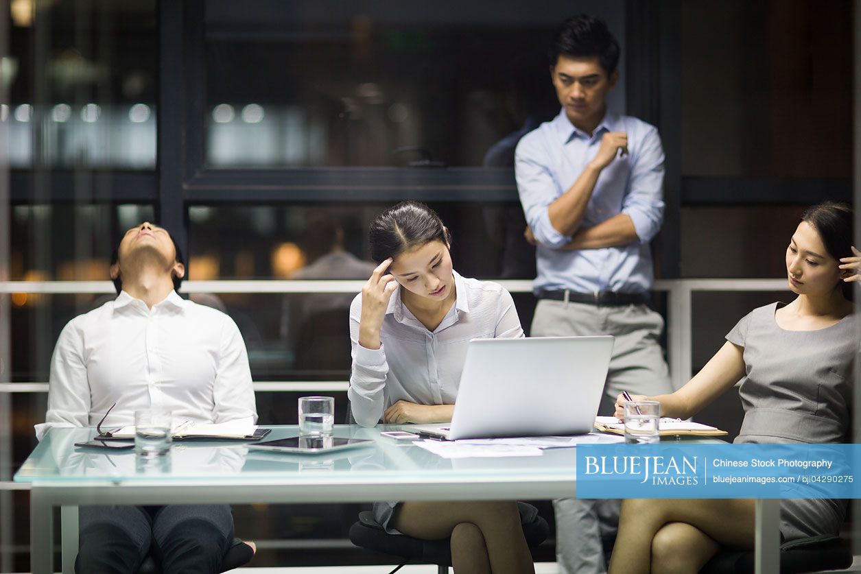 Tired Chinese business people having a meeting