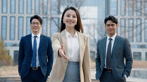 Confident Chinese businesswoman shaking hands outdoors