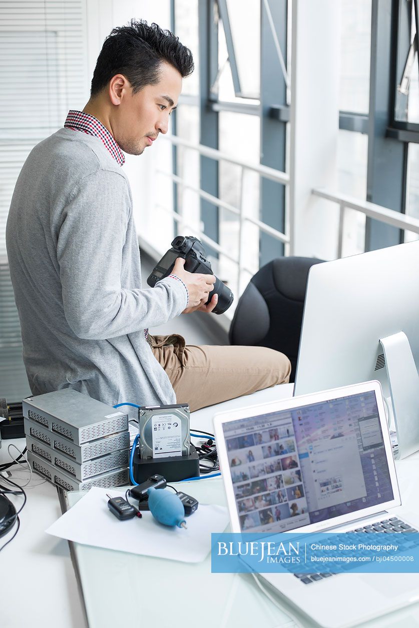 Male Chinese photographer working in office