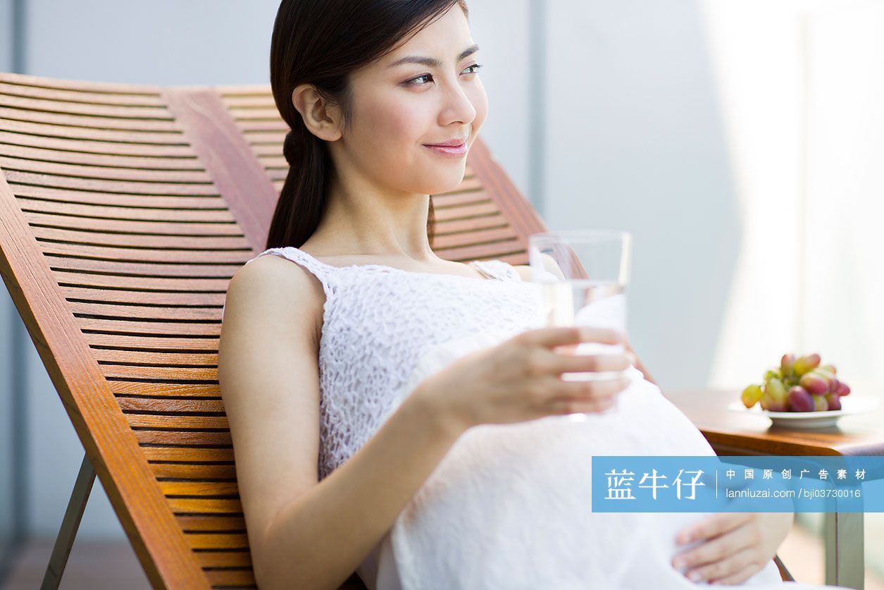 孕妇靠在躺椅上喝水