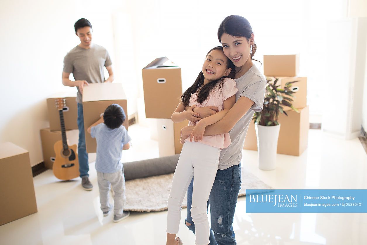 Happy young Chinese family moving to a new house