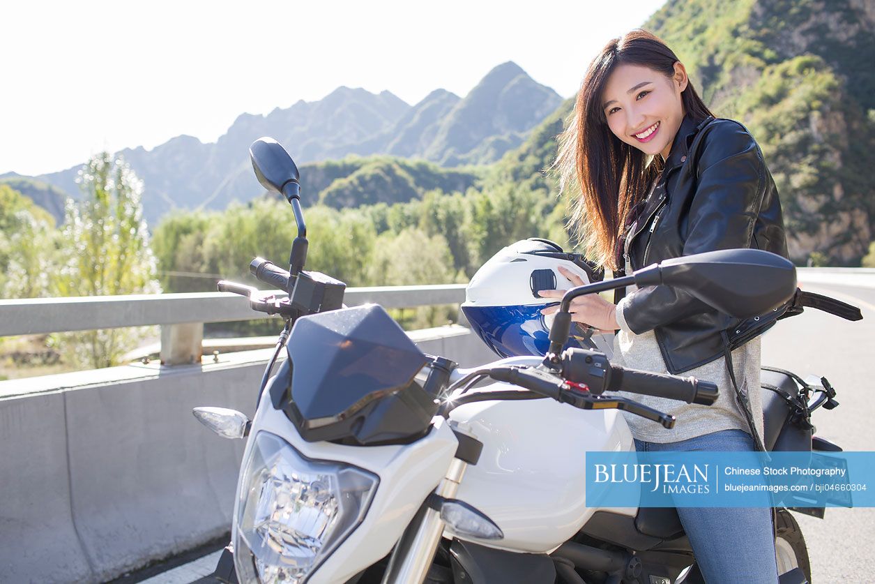 Young Chinese woman riding motorcycle