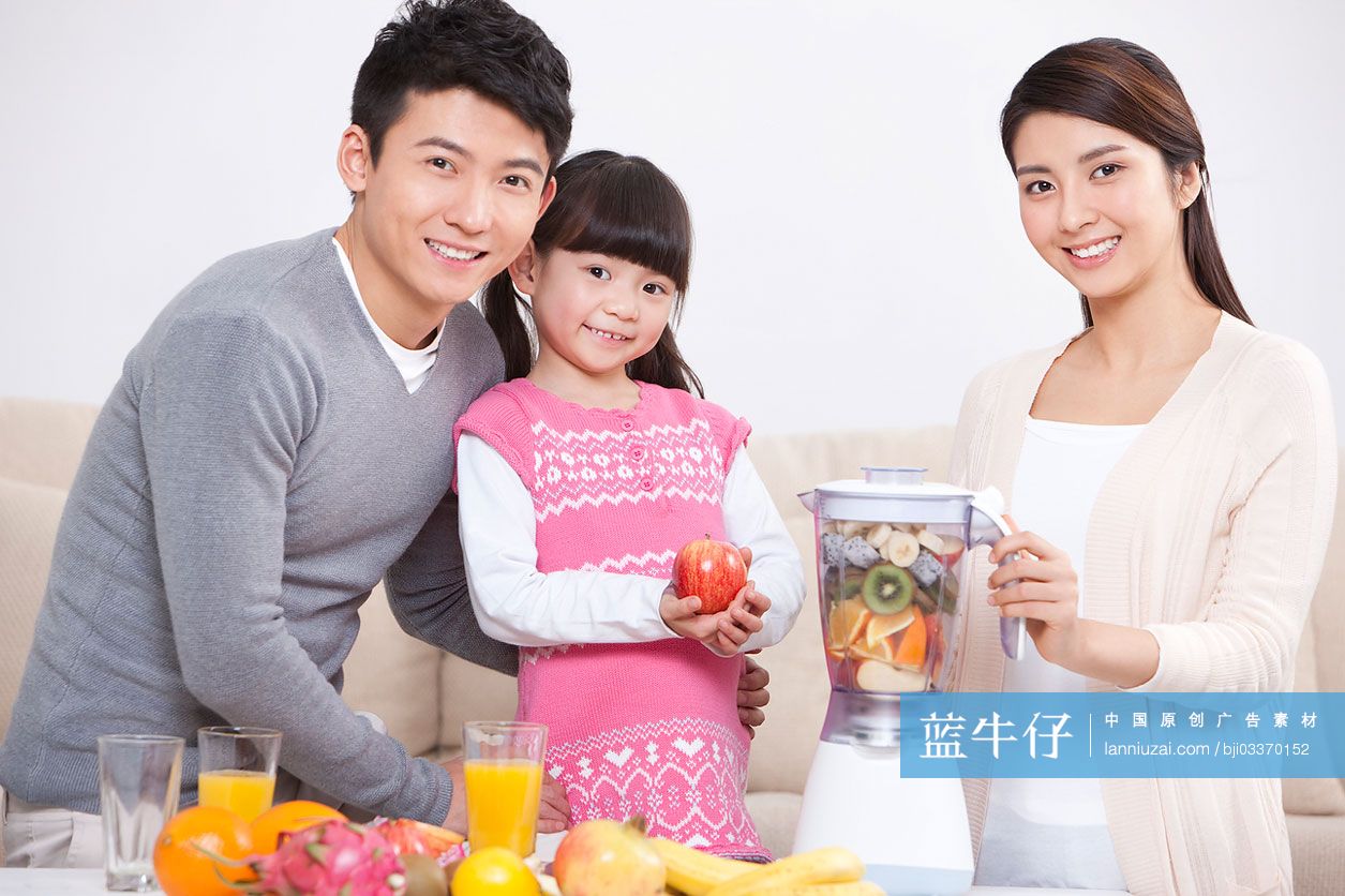 开心的一家人使用榨汁机做果汁