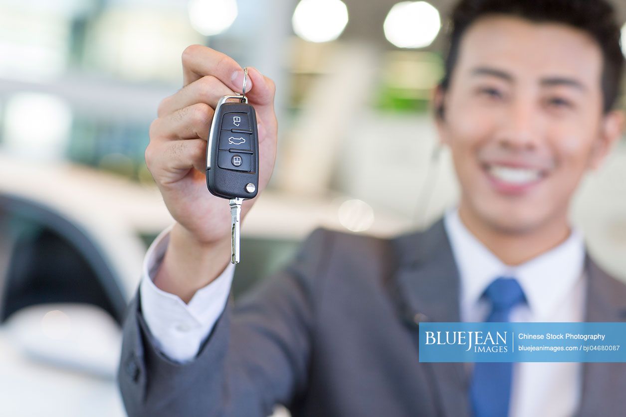 Chinese salesman showing car key