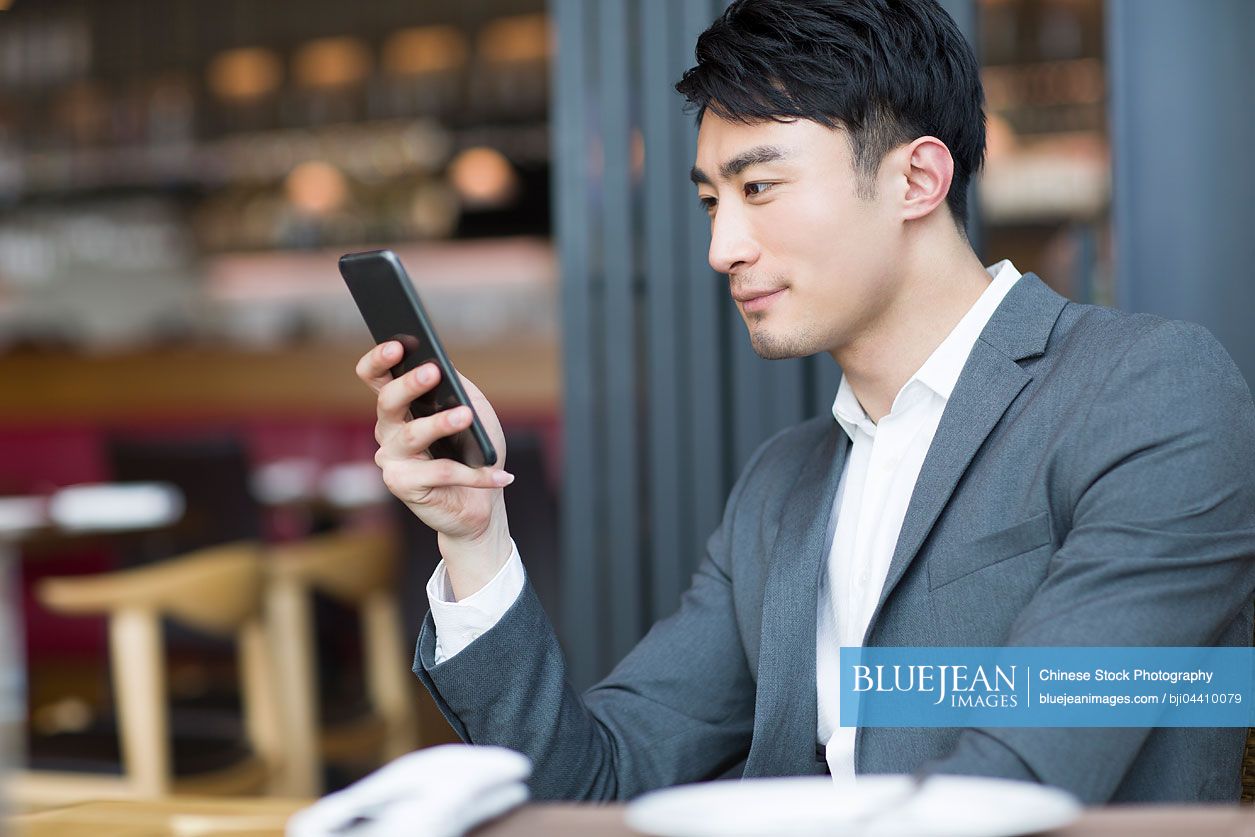 Young Chinese man using smart phone