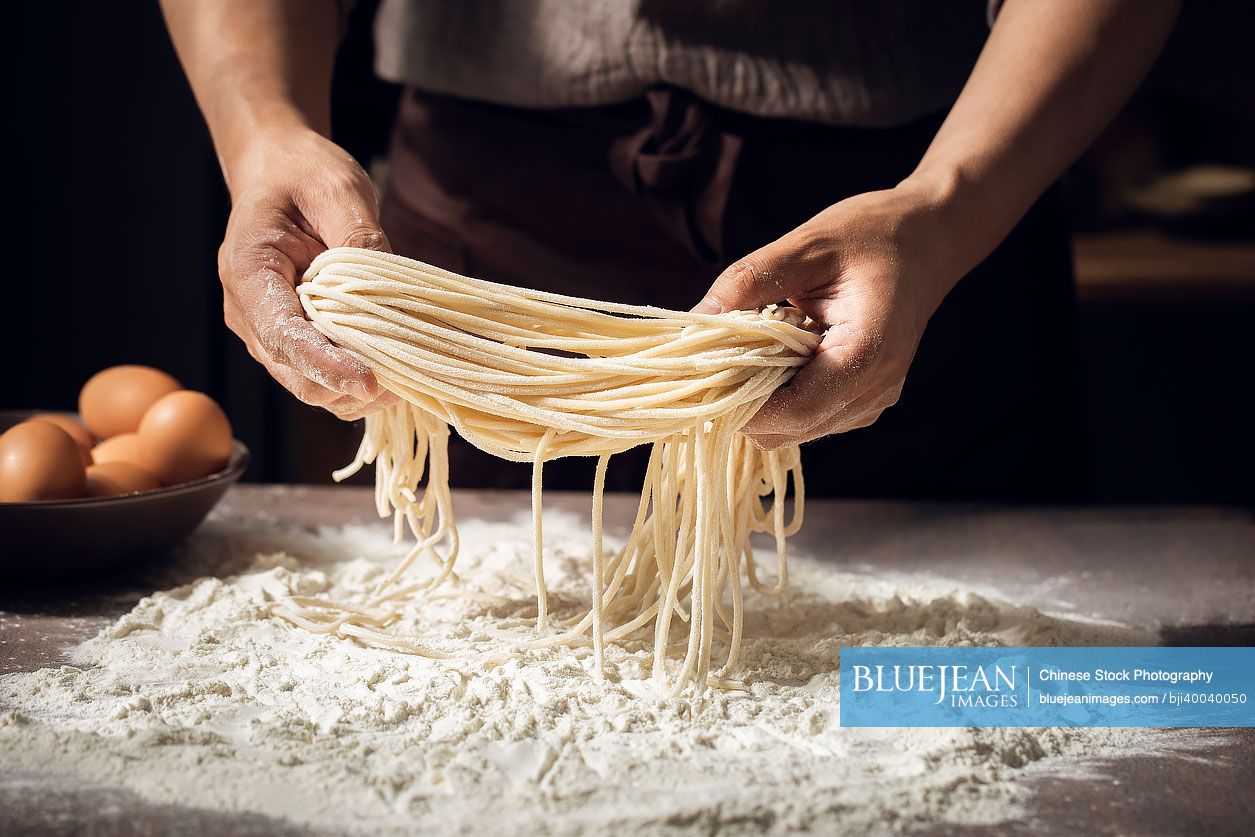 Midsection of chef making noodles