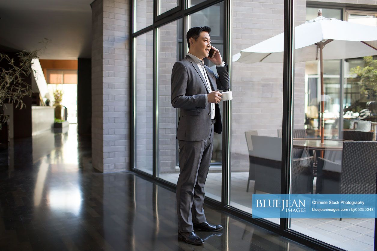 Confident Chinese businessman talking on cell phone