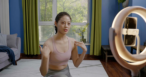 Female fitness influencer live-streaming a yoga session