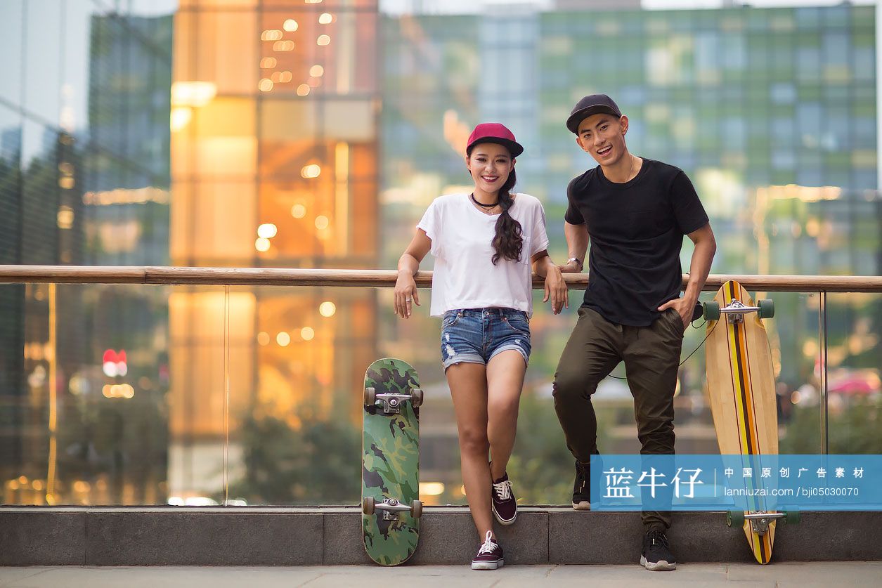 带着滑板的快乐年轻情侣肖像