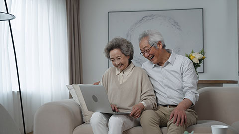 Cheerful senior Chinese couple using laptop at home,4K