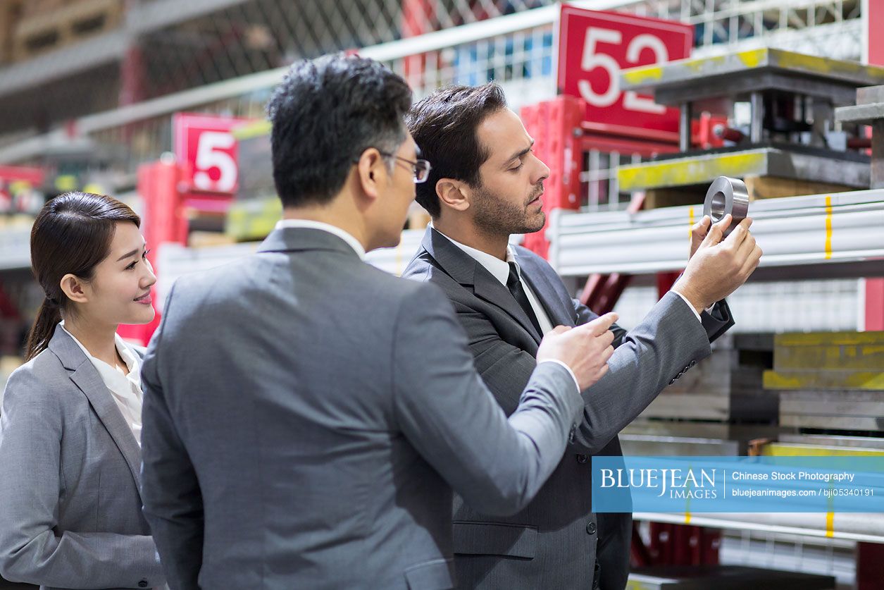 Business people checking machine parts in the factory