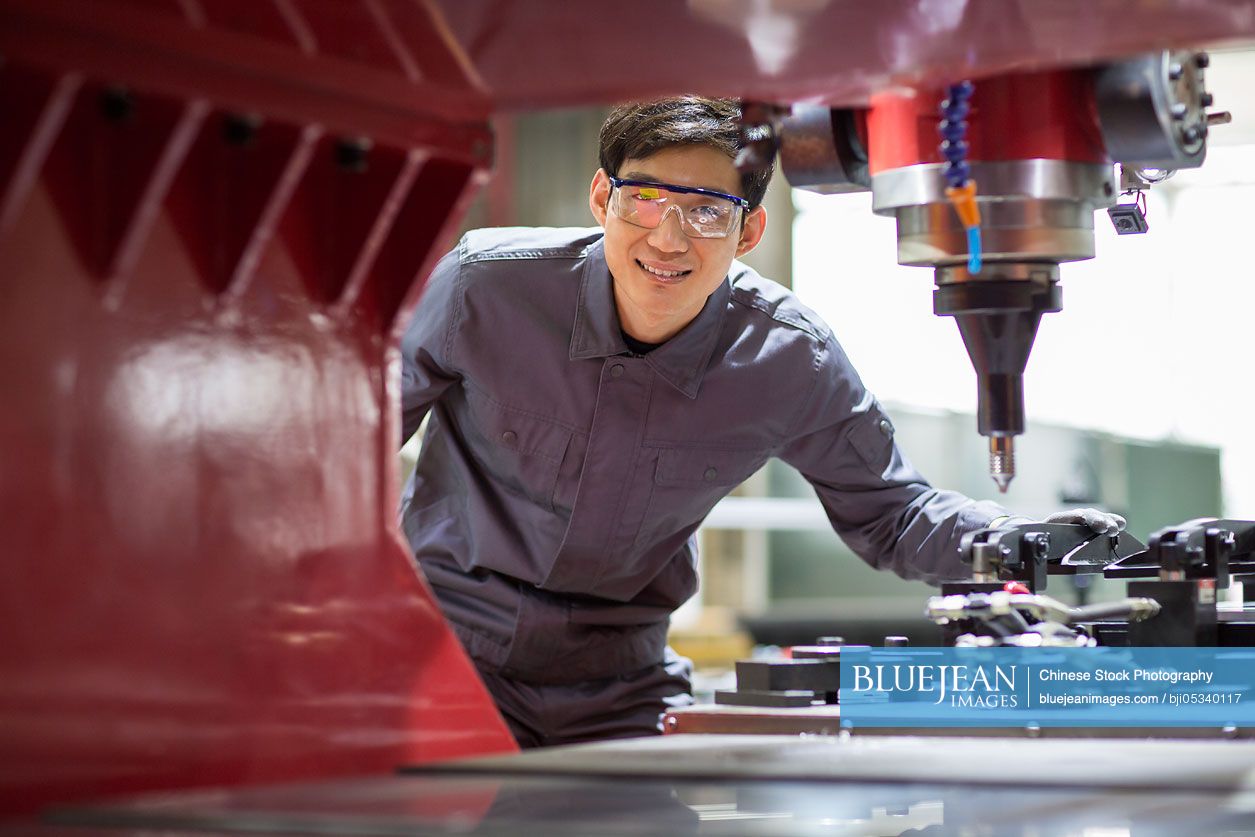 Young Chinese engineer working in the factory