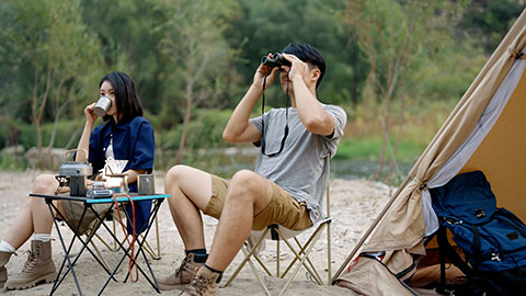 Happy young Chinese couple camping outdoors