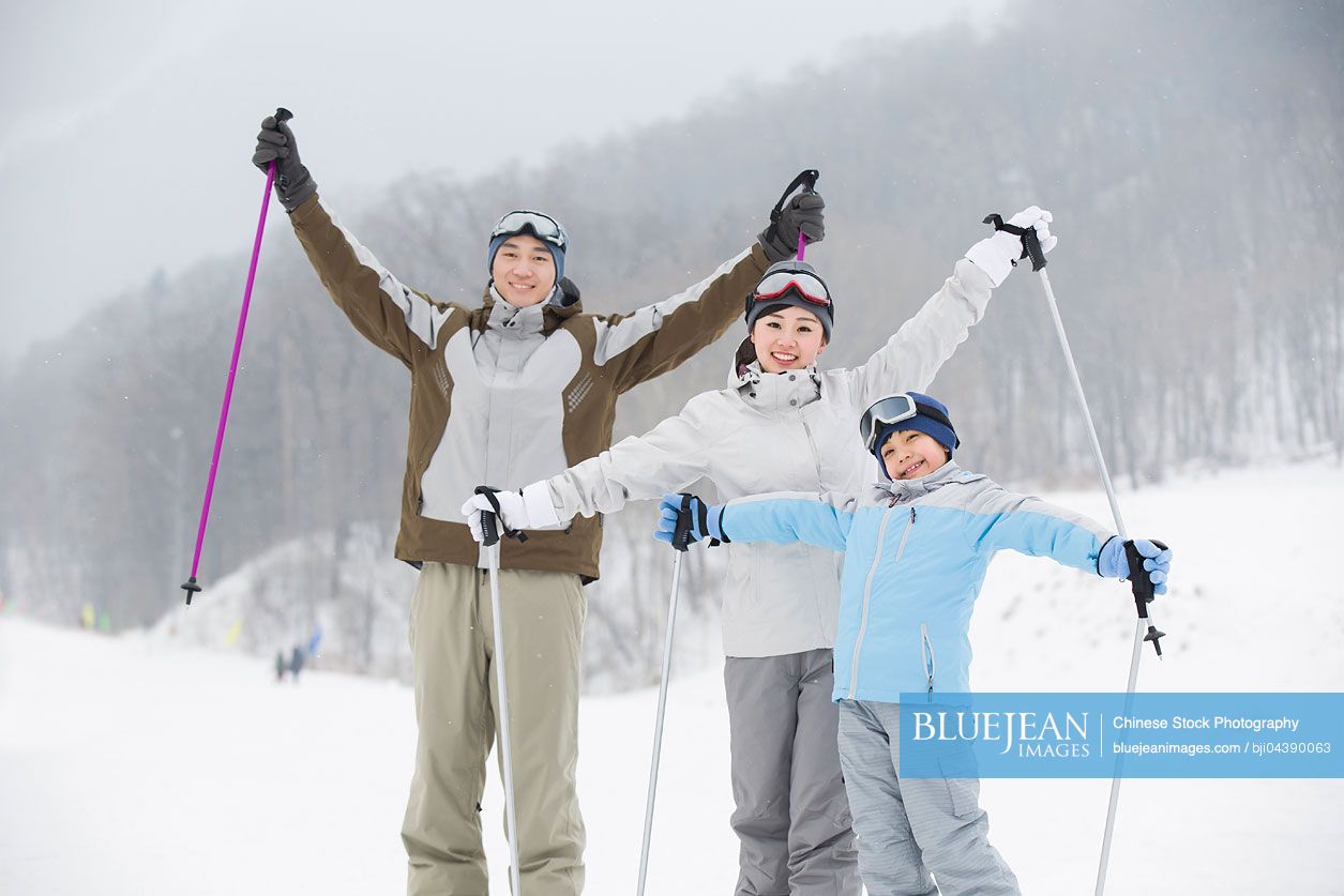Young Chinese family skiing in ski resort