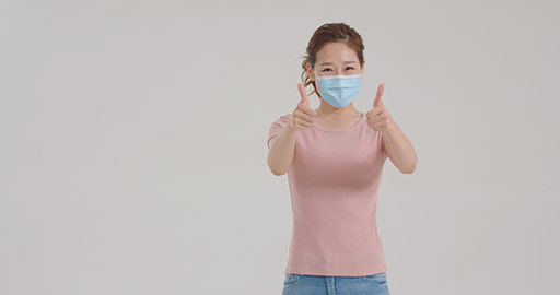 Young Chinese woman with surgical mask doing thumbs-up,4K