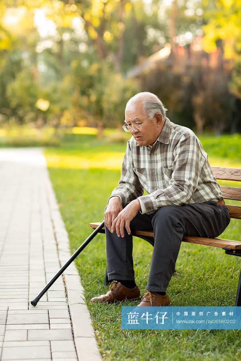 孤独的老人坐在公园长椅上