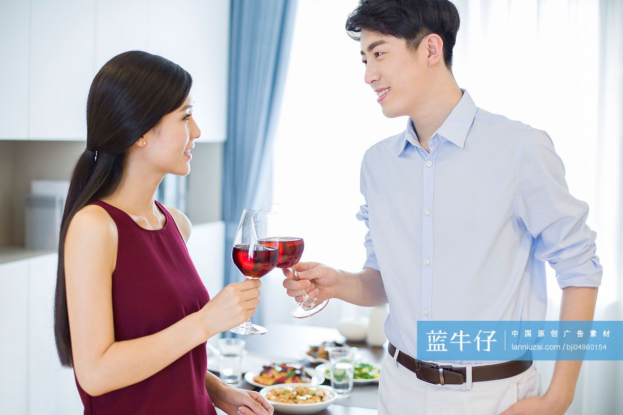 年轻夫妇在家喝红酒庆祝
