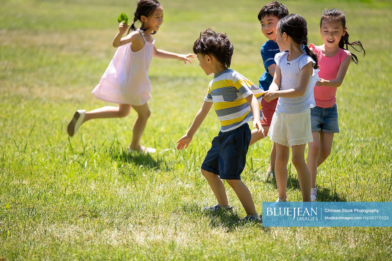 Happy Chinese children playing games on meadow