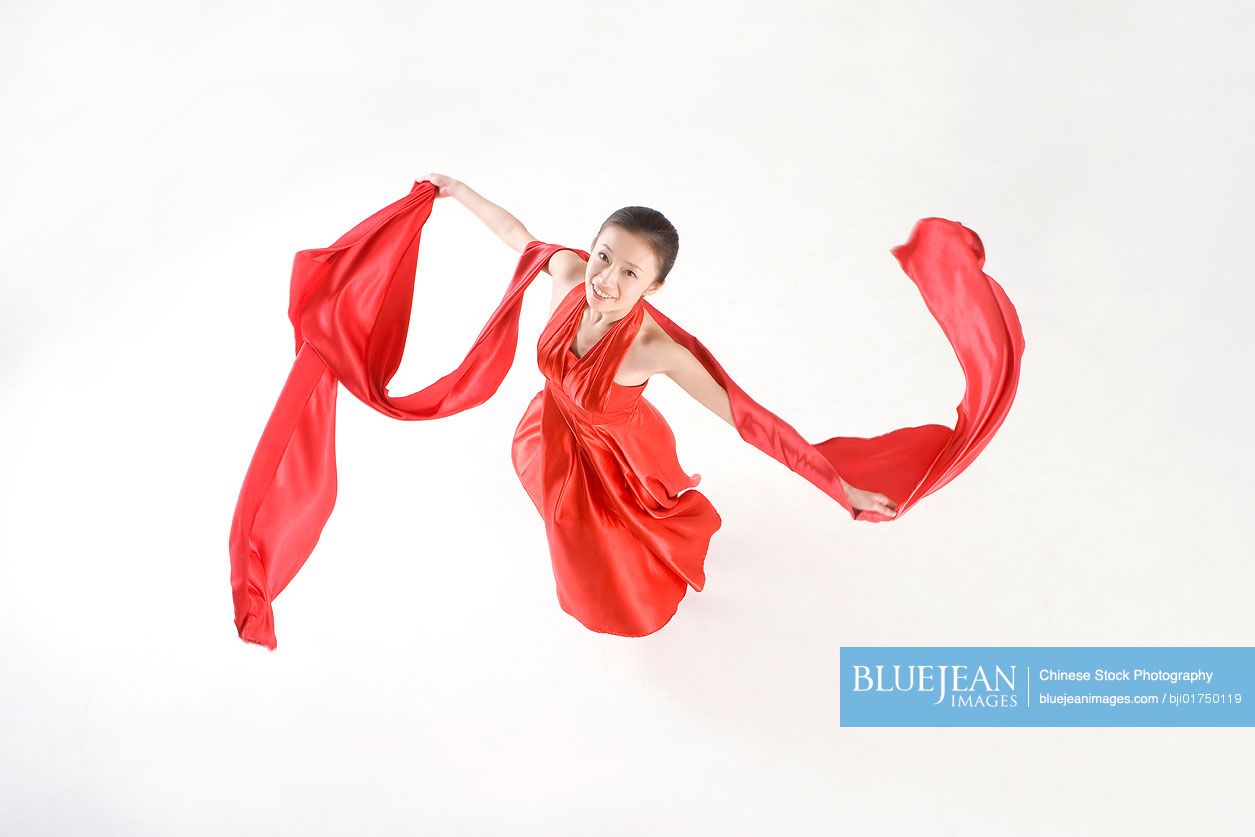 Young Chinese woman in a red dress dancing