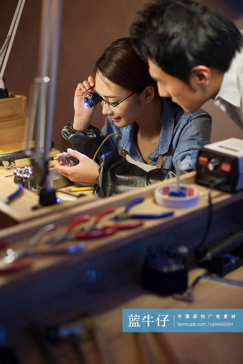 珠宝设计师用微型放大镜检查珠宝