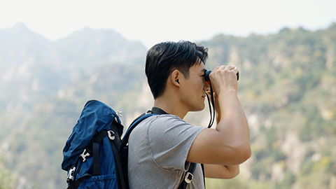 Young Chinese man hiking outdoors